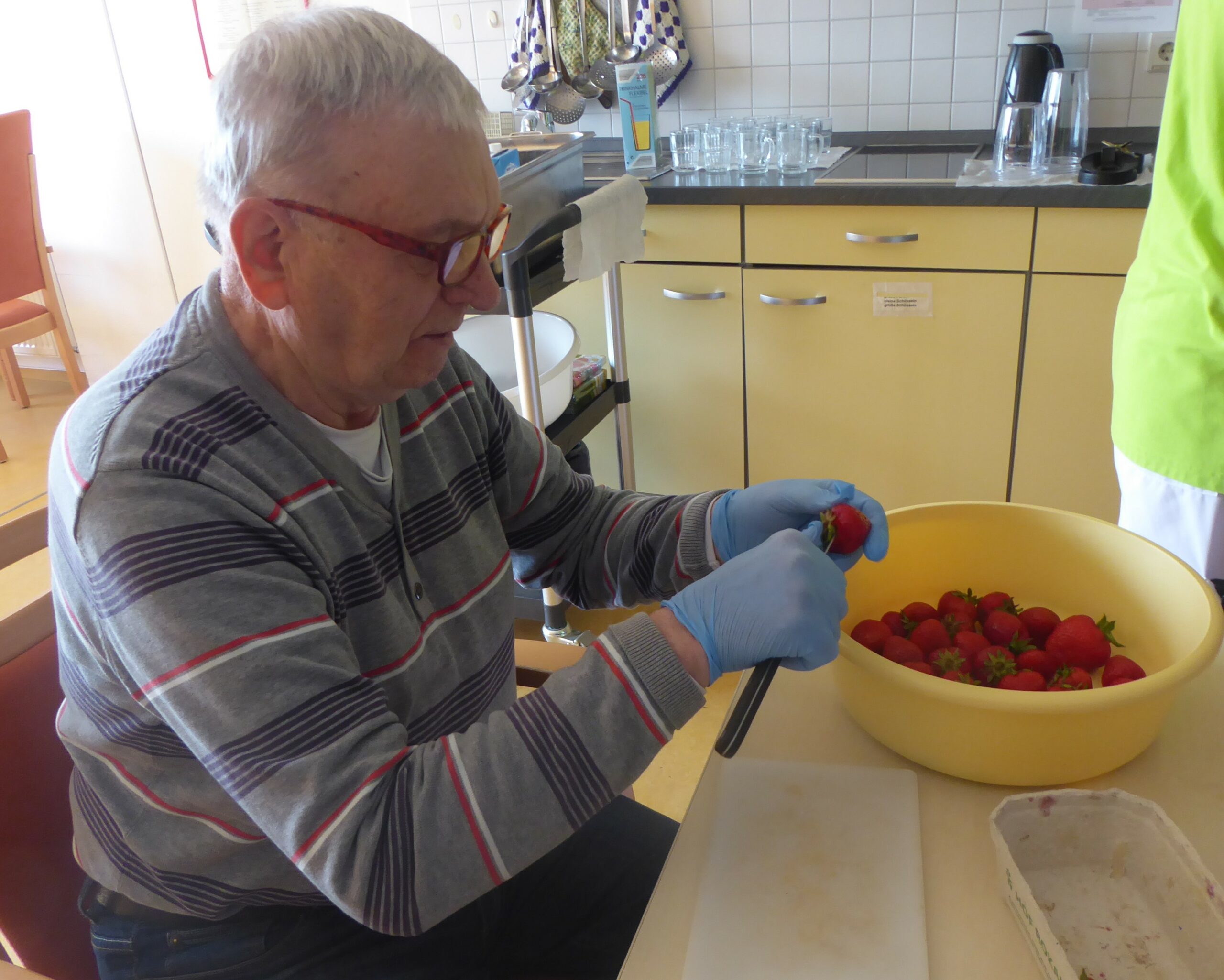 ein Bewohner putzt die Erdbeeren