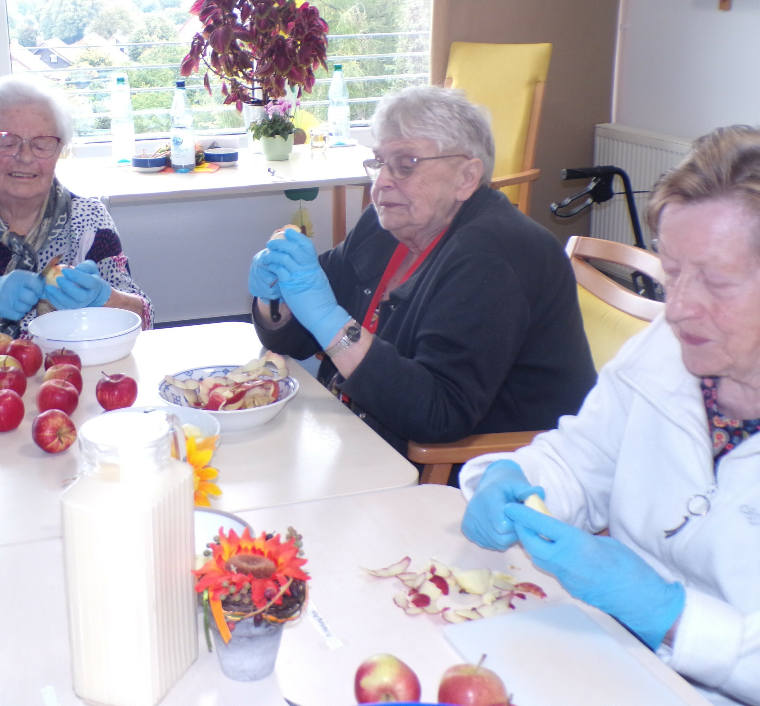 weitere Bewohnerinnen schälen Äpfel