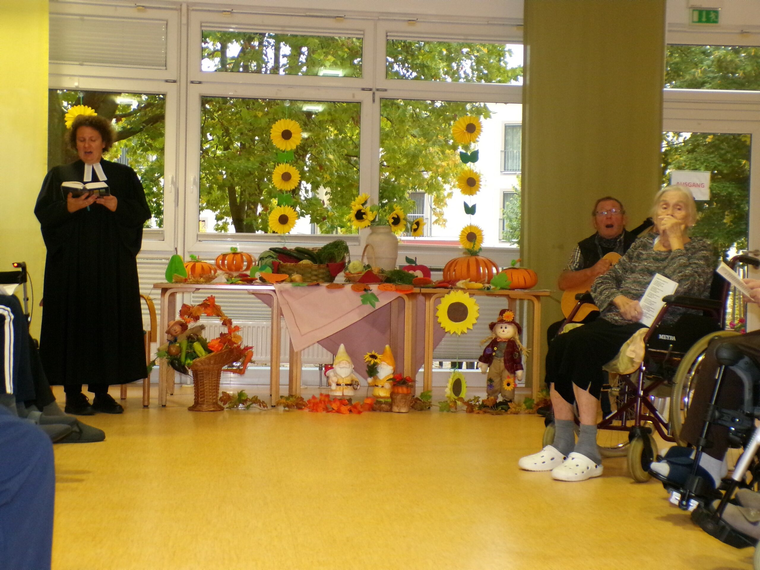 der Gottesdienst, die Bewohner*innen singen mit der Priesterin ein Lied
